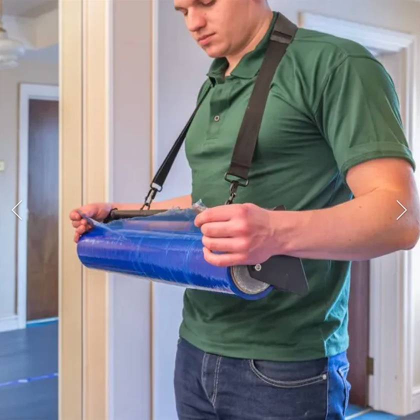 Person holding a blue object with a strap over a white door