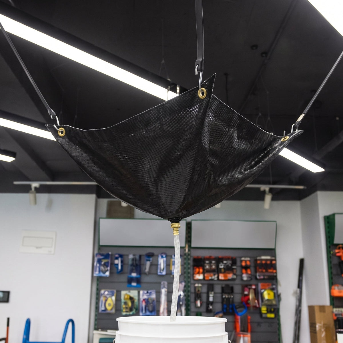 Black ceiling leak diverter in use catching a roof leak into a bucket (152 x 152cm)