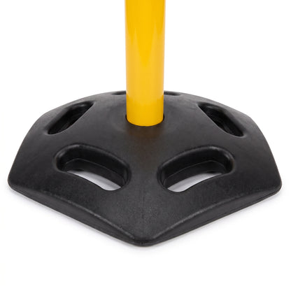 A close-up of a black plastic base with cutout slots and a yellow pole inserted vertically in the center, shown on a white background.